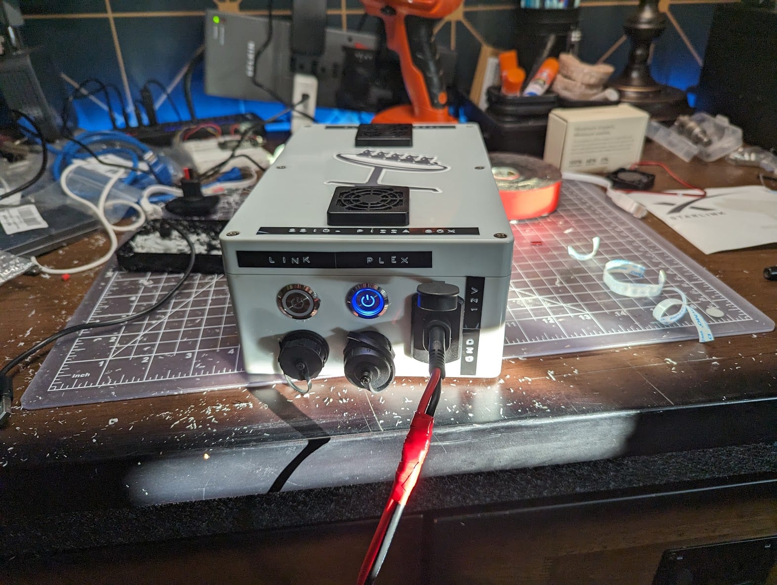 The completed light gray Starlink box on a workbench, with Link and Plex controls, Ethernet and USB ports, and 12-volt sockets across the front panel.