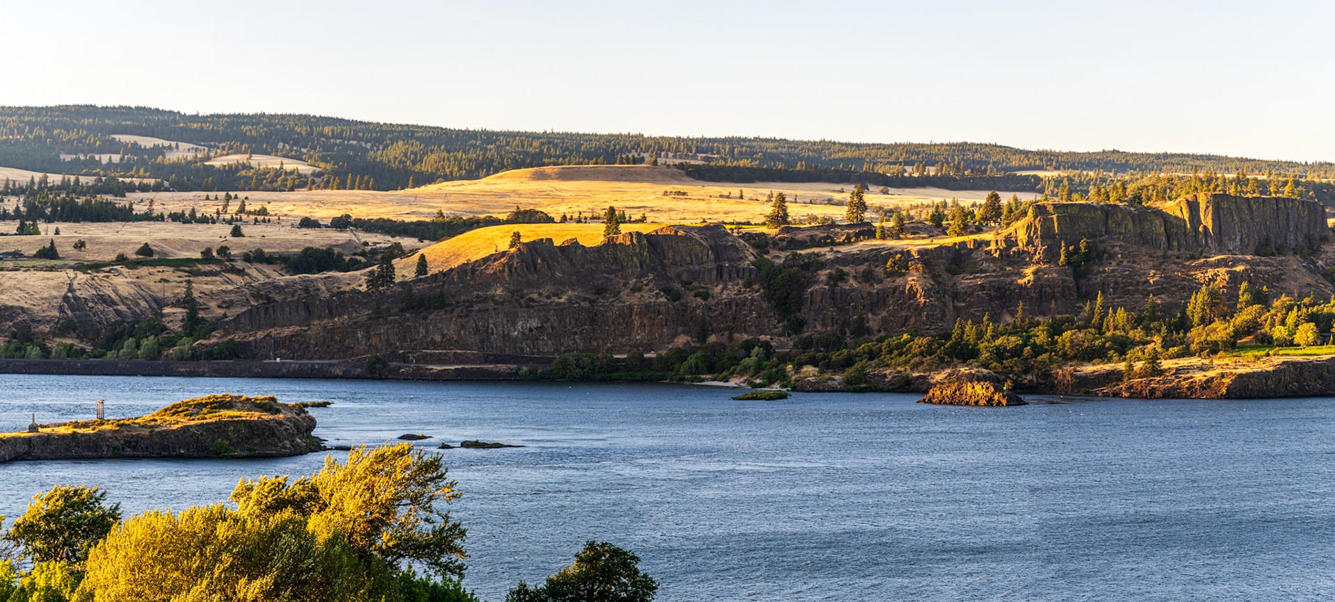 A long view down the river with autumn yellow trees along the near shore.